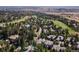 Aerial view of a well-manicured neighborhood and golf course nestled among lush trees with mountain vistas at 3104 Ramshorn Dr, Castle Rock, CO 80108