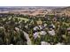 An aerial view of a neighborhood with mature trees, rolling hills, and a golf course under a clear sky at 3104 Ramshorn Dr, Castle Rock, CO 80108