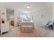 A bright bedroom with a floral cushioned bench, a cozy chair, and an attached bathroom, bathed in natural light at 3104 Ramshorn Dr, Castle Rock, CO 80108
