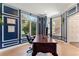 Well-appointed office with blue paneled walls, large windows, and a wooden desk, perfect for a home office at 3104 Ramshorn Dr, Castle Rock, CO 80108