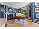 Stylish office with dark blue walls, white trim, fireplace, and large window overlooking the lush yard at 3104 Ramshorn Dr, Castle Rock, CO 80108