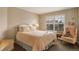 Comfortable bedroom with white metal bed frame, window and accent chair at 2359 Indian Paintbrush Cir, Highlands Ranch, CO 80129