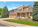 Inviting home with a manicured lawn, brick accents, and a charming front porch with chairs at 2359 Indian Paintbrush Cir, Highlands Ranch, CO 80129