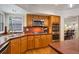 Traditional kitchen features wood cabinets, stainless steel appliances, red countertops, and wood floors at 2359 Indian Paintbrush Cir, Highlands Ranch, CO 80129