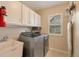 Functional laundry room with modern washer/dryer, sink, and overhead storage at 2359 Indian Paintbrush Cir, Highlands Ranch, CO 80129