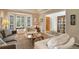 Neutral living room featuring a plush sofa, arm chairs, bay window, and a view of the home's entry at 2359 Indian Paintbrush Cir, Highlands Ranch, CO 80129