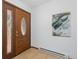 Welcoming home entryway with a decorative glass side-light and adjacent wall art at 23855 Mormon Dr, Conifer, CO 80433