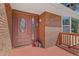 Close-up of the home's front entrance featuring a beautiful decorative glass door and brick facade at 23855 Mormon Dr, Conifer, CO 80433