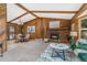 Spacious living room with a brick fireplace, wood paneled walls, and an adjacent dining area at 23855 Mormon Dr, Conifer, CO 80433