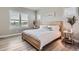 Bright bedroom featuring a wooden bed frame, hardwood floors, and plantation shutters at 6805 Zebra Grass Ln, Parker, CO 80138