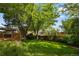 An expansive backyard featuring mature trees, a wood deck, lush lawn, and well-maintained landscaping at 9174 Lark Sparrow Pl, Highlands Ranch, CO 80126