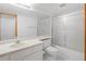Functional bathroom featuring a shower-tub combo with sliding glass doors and a large mirror at 9174 Lark Sparrow Pl, Highlands Ranch, CO 80126