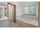 Bright bathroom features a large soaking tub, shower, and window at 9174 Lark Sparrow Pl, Highlands Ranch, CO 80126