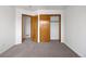Bedroom features closet, neutral carpet, white walls, and a wooden door at 9174 Lark Sparrow Pl, Highlands Ranch, CO 80126