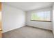 Bedroom with a window that offers natural light, neutral carpet, and white walls at 9174 Lark Sparrow Pl, Highlands Ranch, CO 80126
