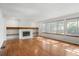 Bright living room with hardwood floors, fireplace, built-in shelving, and large windows at 9174 Lark Sparrow Pl, Highlands Ranch, CO 80126