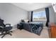 Comfortable bedroom with a cozy bed, window, dark accents, and an office chair at 11022 Newark St, Commerce City, CO 80640