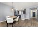 Cozy dining room with modern lighting, a wooden table, and comfortable seating adjacent to the kitchen at 11022 Newark St, Commerce City, CO 80640