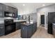 Stylish kitchen with dark cabinetry, granite countertops, and a central island for food preparation and dining at 11022 Newark St, Commerce City, CO 80640