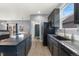 Functional kitchen featuring dark cabinets, stainless steel appliances, and granite counters with backyard views at 11022 Newark St, Commerce City, CO 80640