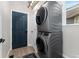 Convenient laundry room with stacked washer and dryer units, a utility sink, and a storage cabinet at 11022 Newark St, Commerce City, CO 80640