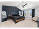 Spacious main bedroom with a dark accent wall, ceiling fan, two bright windows, and modern decor at 11022 Newark St, Commerce City, CO 80640