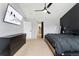 Bright main bedroom featuring black accents, a ceiling fan, a TV, and access to the ensuite bathroom at 11022 Newark St, Commerce City, CO 80640