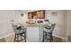 Basement bar area featuring granite counters, wood cabinets and two comfortable stools at 1553 Plowman Dr, Monument, CO 80132