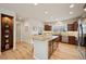 Bright kitchen features an island with granite countertops, stainless steel appliances, and beautiful wood flooring at 1553 Plowman Dr, Monument, CO 80132