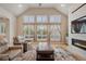 Sunlit living room featuring a cozy fireplace, large windows with shutter blinds, and stylish seating on hardwood floors at 1553 Plowman Dr, Monument, CO 80132