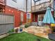 Inviting brick backyard with stone patio, grass turf, and string lights for outdoor entertaining at 2524 Champa St # 1, Denver, CO 80205
