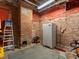 Basement with exposed brick walls, ladder and grey rubber flooring at 2524 Champa St # 1, Denver, CO 80205
