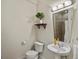 Cozy bathroom features a pedestal sink, neutral walls, and a decorative plant on a floating shelf at 2524 Champa St # 1, Denver, CO 80205
