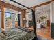 Bedroom showcasing a canopy bed, exposed brick, and French doors, connected to a living area and outdoor balcony at 2524 Champa St # 1, Denver, CO 80205