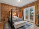 Charming bedroom with exposed brick, canopy bed, and French doors leading to outdoor seating at 2524 Champa St # 1, Denver, CO 80205
