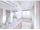 Light and airy bathroom featuring dual sinks, a soaking tub, and a large window at 1431 Beacon Hill Dr, Highlands Ranch, CO 80126
