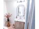 Stylish powder room featuring a modern vanity, arch mirror, and decor accents with warm neutral paint at 1431 Beacon Hill Dr, Highlands Ranch, CO 80126