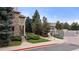 Well-manicured landscaping leads to the Pinnacle Ranch community entrance with lush trees at 9944 E Carolina Cir # 201, Aurora, CO 80247