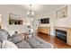 Inviting living room with fireplace, mounted TV, hardwood floors, and open access to dining at 9944 E Carolina Cir # 201, Aurora, CO 80247