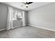 Bright bedroom with gray walls, wood-look floors, a ceiling fan, and a large window with white curtains at 343 W Lehow Ave # 14A, Englewood, CO 80110