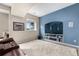 Finished basement featuring a blue accent wall with built-in shelving and large entertainment area at 12665 S Robinson Ranch Ct, Parker, CO 80134