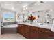 This bath features a soaking tub with tile surround, double sinks, and large window with great views at 12665 S Robinson Ranch Ct, Parker, CO 80134