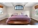 Large bedroom features include wood floors, lots of natural light and an arch window with blinds above the bed at 12665 S Robinson Ranch Ct, Parker, CO 80134