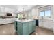 Modern kitchen with white cabinets, island with green base, and stainless steel appliances at 12665 S Robinson Ranch Ct, Parker, CO 80134