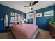 Cozy bedroom with blue walls, ceiling fan, carpet flooring, and a bed with pink bedding at 7744 S Oneida Ct, Centennial, CO 80112