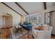 Bright living room featuring hardwood floors, beamed ceilings, a bay window, and stylish decor at 7744 S Oneida Ct, Centennial, CO 80112