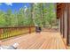 Large wood deck with a wood railing surrounded by pine and aspen trees at 30122 Nancys Ln, Conifer, CO 80433