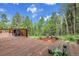 Wooden deck featuring outdoor seating, offering views of the surrounding trees at 30122 Nancys Ln, Conifer, CO 80433