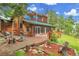 Wooden deck with a seating area and grill that overlooks a backyard surrounded by trees at 30122 Nancys Ln, Conifer, CO 80433