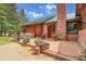 Inviting front entrance with brick walkway and charming flower pots, nestled among mature trees at 30122 Nancys Ln, Conifer, CO 80433